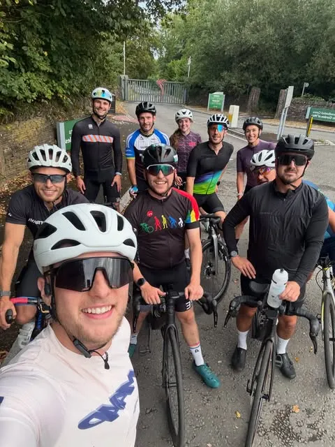 A dozen EndureOne riders in helmets and club kit grinning at the camera before a Thursday evening ride